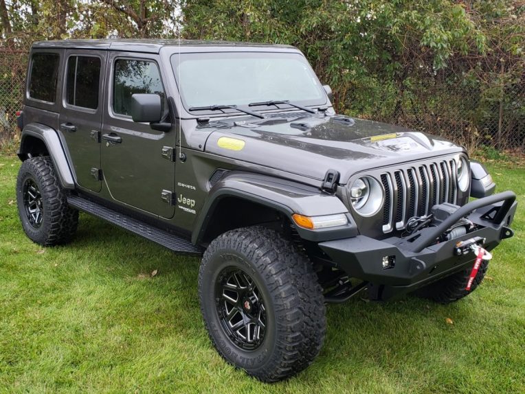 A jeep parked in a grassy area  Description automatically generated with low confidence